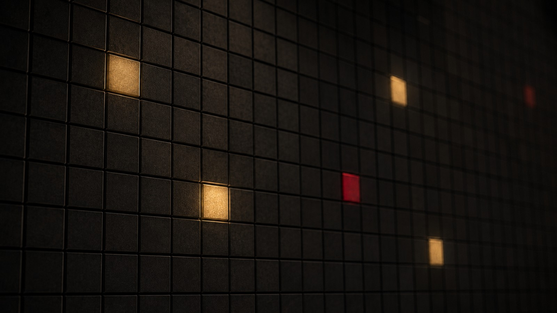 A dark grid of matte square tiles with a few lit in gold and one in red, an abstract image of shifting state by state regulation